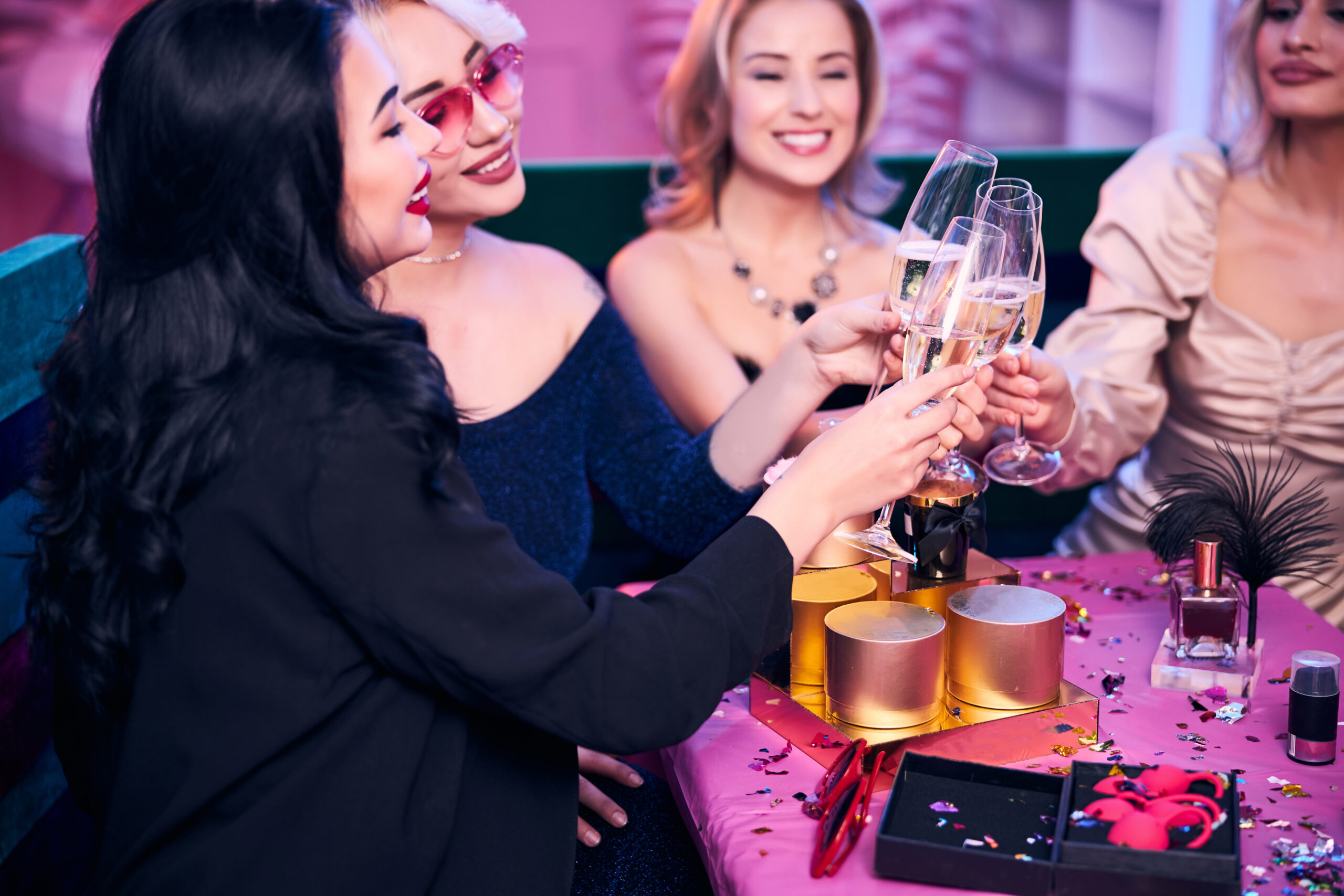 Four women with alcoholic beverages sitting at the party